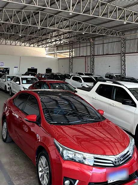 Sedã vermelho no salão coberto da Abreu Autos